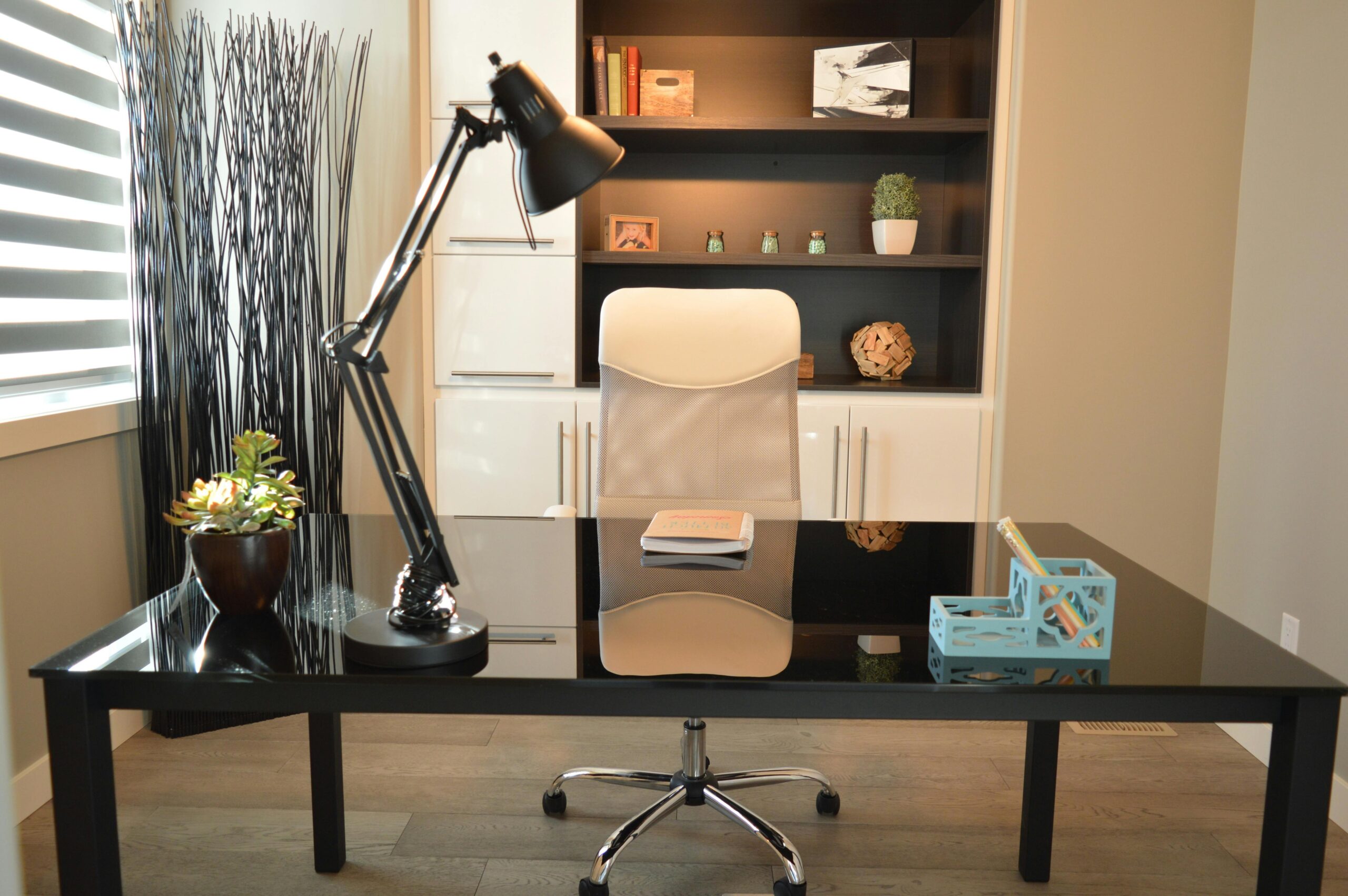 Modern office with a desk, chair, lamp, and decorative plants