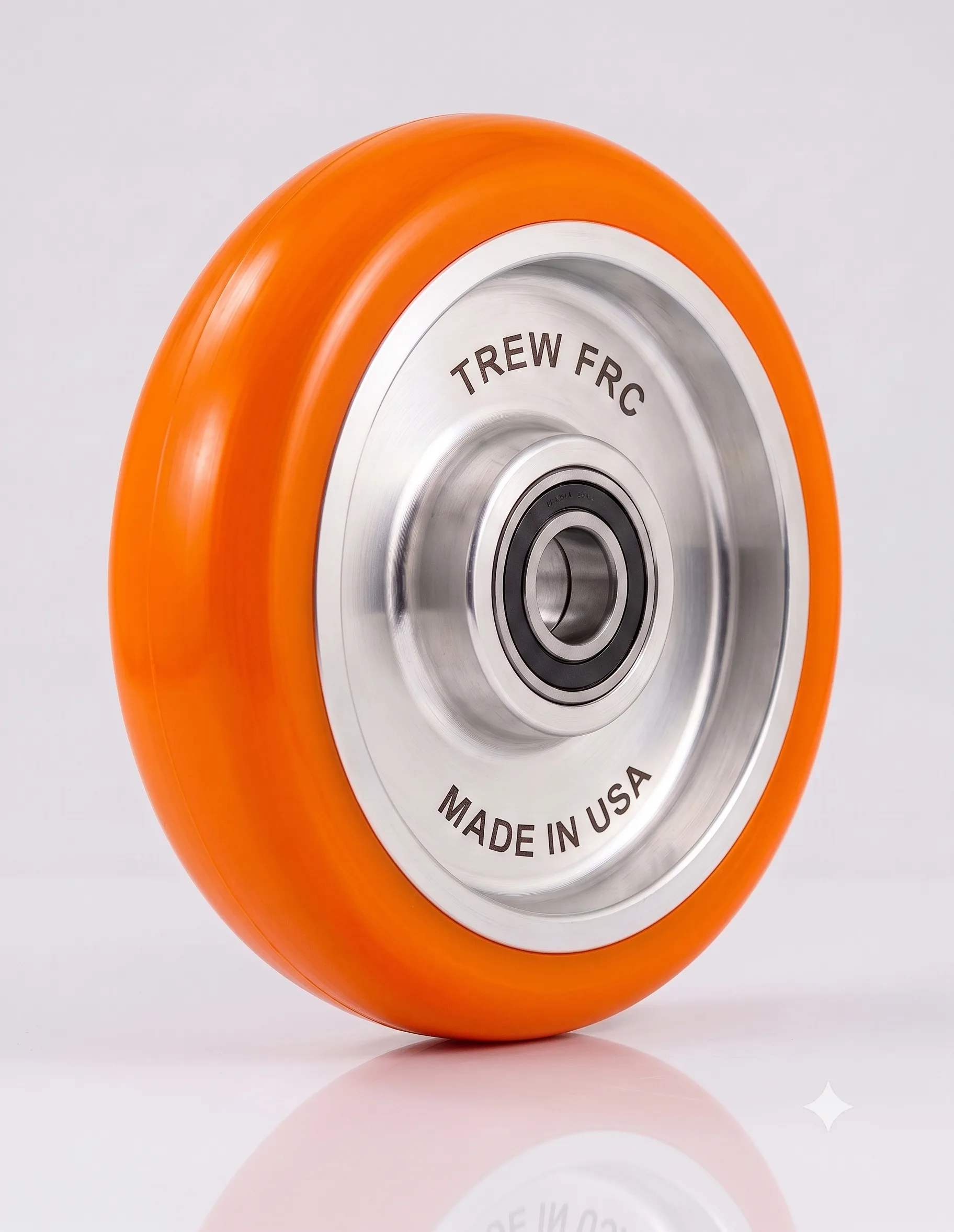 Orange wheel with Made in USA and TREW FRC engraved on metal hub, reflecting high-quality manufacturing.